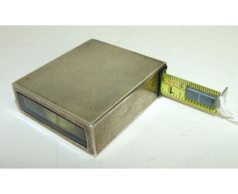 An engine turned silver tape measure marked 925 R+S, 5 x 5.5cm.