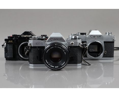 Three Canon SLR Cameras, a Canon AE-1, shutter working, meter responsive, self timer working,  body G, with 50mm f/1.8 SC FD 