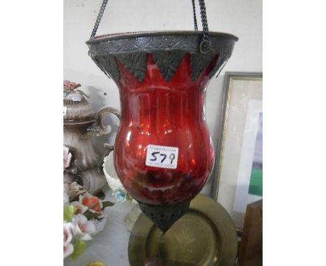 A hanging red glass candle lamp.