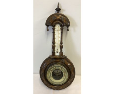 A vintage barometer in carved wood.  