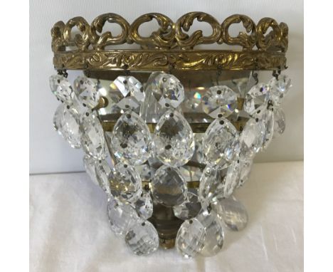 A small ornamental brass mirror backed chandelier style wall light with glass droplets.  Approx. 18cm x 18cm.