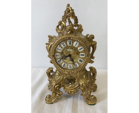 A heavy brass ornamental French style pendulum mantel clock by Johnnie. In working order. Approx. 20.5cm tall.