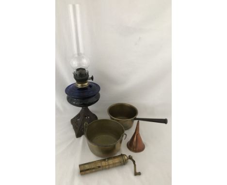 A vintage oil lamp and brassware. Oil lamp with blue glass reservoir. Brassware includes vintage pepper grinder. 