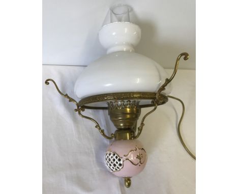 A vintage ceiling hanging light with glass chimney and shade.  