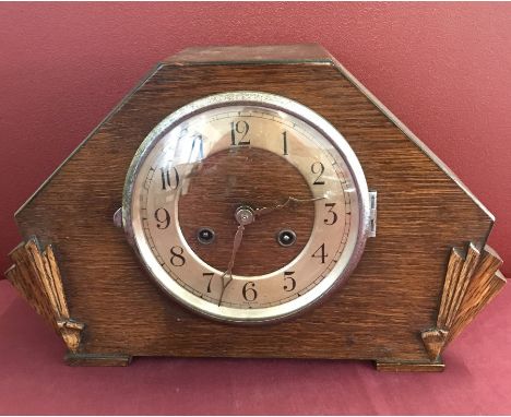 An Art Deco dark wood mantel clock with fan decoration to front. Complete with key and pendulum. 