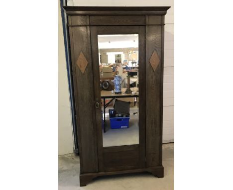 A circa 1930's dark oak single wardrobe with mirrored door and diamond motif to each side.  Approx. 103cm x 108cm tall.