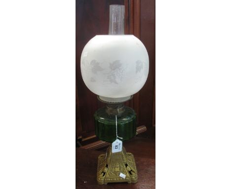 Early 20th Century double burner oil lamp having frosted foliate shade, green glass reservoir on a gilded cast base. (B.P. 24