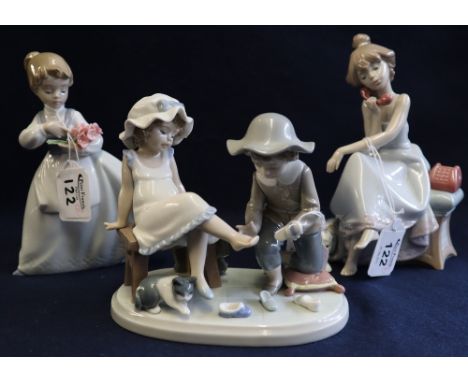 Three items of Spanish porcelain to include Lladro children trying on shoes, Lladro girl on phone with dog, and Nao little gi