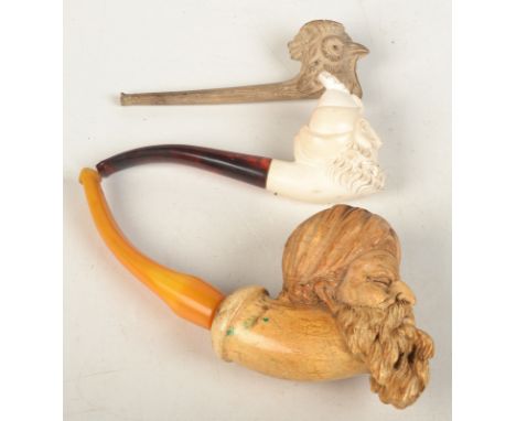 A meerschaum pipe carved with the head of a bearded Turk, together with a similar modern pipe and a clay pipe moulded with th