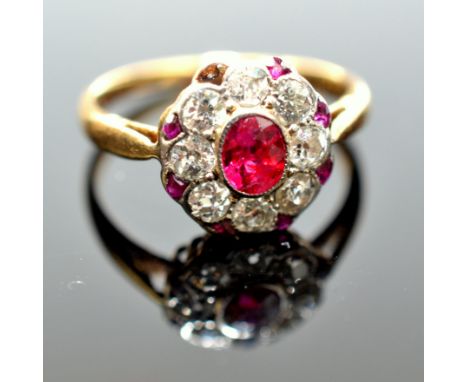 A gold ring with a central oval ruby surrounded by eight diamonds in the angles of these small fan shaped rubies.  Condition 