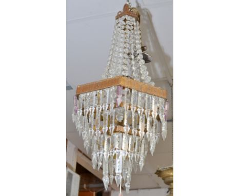 A hexagonal, four tier brass and lustre chandelier.