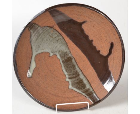 A Janet Leach stoneware shallow bowl biscuit but for two splashes of poured glaze, diameter 33cm, impressed personal and pott