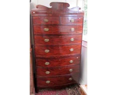 A Regency mahogany veneered, bow front chest on chest with shaped pediment and splayed bracket feet.  Condition report: the 3