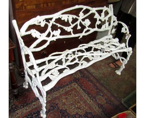 A heavy cast iron garden seat with bound trellises of fruiting oak branches, each end with entwined snakes.