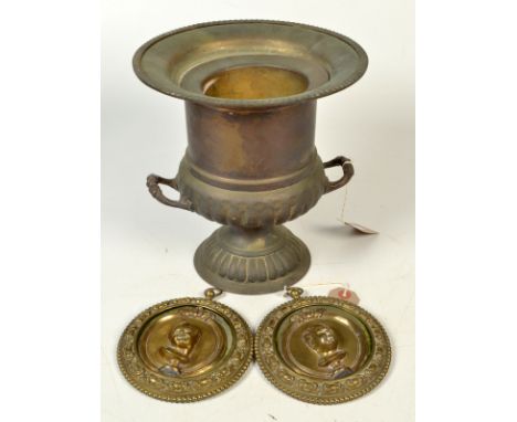 A pair of brass portrait roundels, each with a cast portrait bust of a child, together with an ice bucket. 