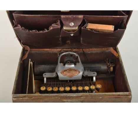 A Blick 1911 aluminium Featherweight typewriter with spare typewheel and instruction manual in a fitted canvas clad case.