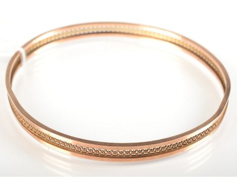 A 9ct. gold bangle with a pierced central band, 9.3g.