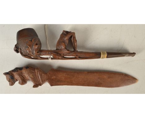 A Swiss carved wood pipe, the stem with a bear holding the Swiss shield, together with a Black Forest carved paper knife.