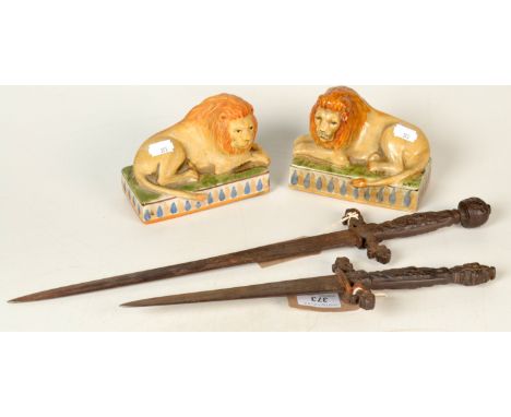 Two daggers with cast iron handles, and a pair of ceramic lions.