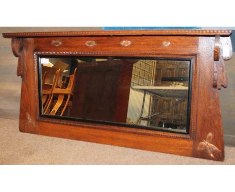 ARTS AND CRAFTS OAK HALL MIRRORof rectangular form with top shelf held with stylised curved supports, decorated with four pla