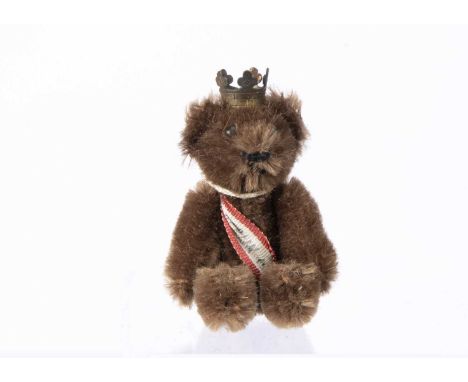 A post war miniature Schuco Berlin teddy bear, with dark brown mohair, black pin eyes, black stitched nose and mouth, swivel 