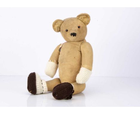 A 1920/30s teddy bear,  possibly French, with remains of blonde mohair, black replacement button eyes, pronounced muzzle, bla