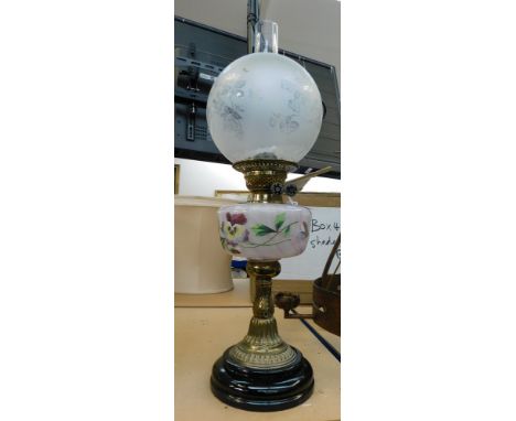 A late 19th century oil lamp, having brass stem leading to hand enamelled font and with flume and shade to top.&nbsp;