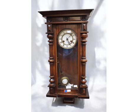 A 20th century mahogany cased wall clock with pendulum and winding key, no finial and untested.