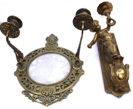 A 20th century cast brass wall sconce modelled as a young boy holding the candle holder, wall attachment with cast floral des