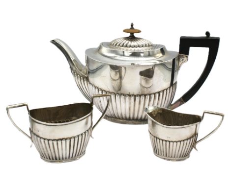 A matched late Victorian three piece tea set, all of oval gadrooned shape, tea pot with angular ebonised handle and  wooden f