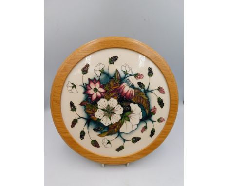 A Moorcroft Plaque in the Bramble revisited design by Alicia Amison, in wooden surround, total diameter approximately 30.5cm,