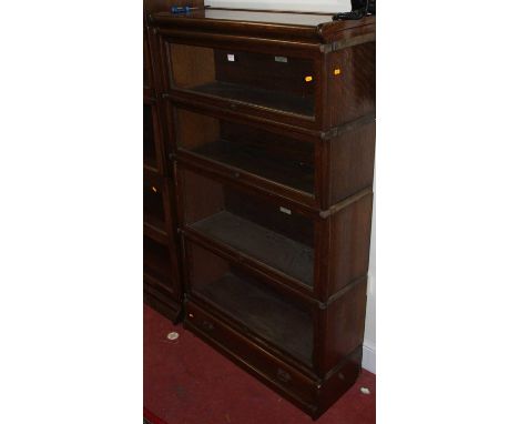 A 1930s oak four-tier stacking bookcase by the Globe Wernicke Company, having typical hinged glazed doors, with single long l