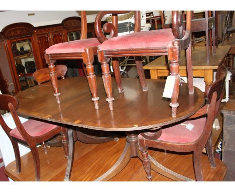 A reproduction mahogany and yew wood crossbanded twin pillar dining table in the Regency taste, with single extra drop-in lea