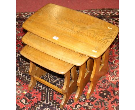 An Ercol mid-elm nest of three occasional tables, the largest w.56cm