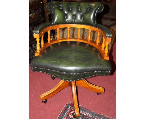 A contemporary beech and green leather button upholstered and further tub swivel desk chair on roller castors, width 61cm