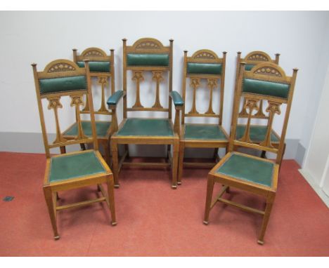 A Set of Six Oak Art Nouveau Dining Chairs, the top rail carved with stylised flowers, upholstered back panel and seat with s