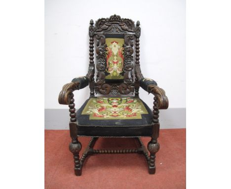 A XIX Century Carved Oak Armchair, the top rail carved with a crown flanked by angels, bobbin supports, woolwork tapestry bac