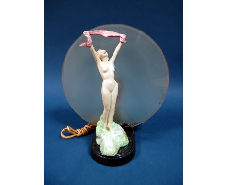 An Art Deco Crown Devon Pottery Figural Table Lamp, depicting a naked young woman holding a pink ribbon, stood on a grassy kn