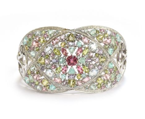 A heavy 18ct white gold, tourmaline and diamond bangle, set with a total of 25.2cts of stones including a central 1.15ct cush