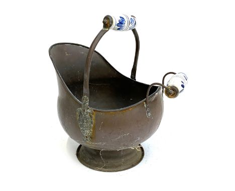 A copper coal scuttle with blue and white ceramic handles
