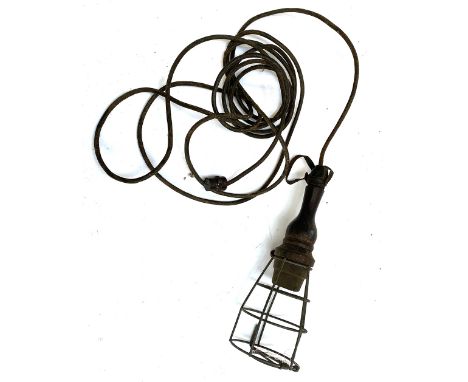 A vintage electric work light, with turned wooden 'handle', and leather hanging strap