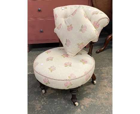 A small buttonback bedroom chair on turned legs and ceramic casters, upholstered in a floral print