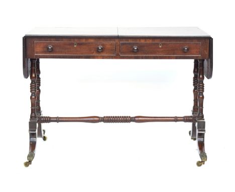 A Regency mahogany sofa table, with two frieze drawers raised on ring turned supports joined by a central ring turned stretch