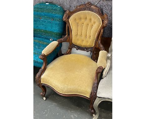 A Victorian carved walnut and button upholstered armchair, with ceramic casters, 71cmW