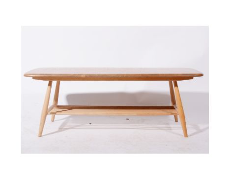 An elm and beech coffee table with magazine rack undertier by Ercol, length 104cm, width 46cm, height 36cm.