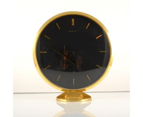 An eight day Jaeger LeCoultre mantel clock with floating hands, 1960s, the gilt metal circular case housing a black dial with