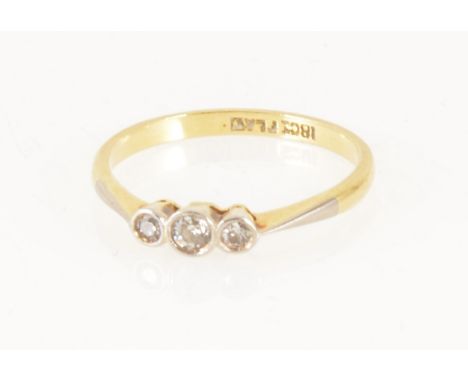 A diamond three stone ring, the old brilliant cut stones collet set in a yellow and white metal traditional three stone mount