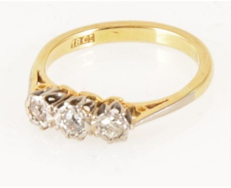 A diamond three stone ring, the old brilliant cut stones illusion set in a yellow and white metal traditional three stone mou