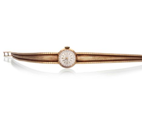 OMEGA NINE CARAT GOLD MANUAL WIND WRIST WATCH, the round dial with baton hour markers, 17mm case, on a snake bracelet, in box