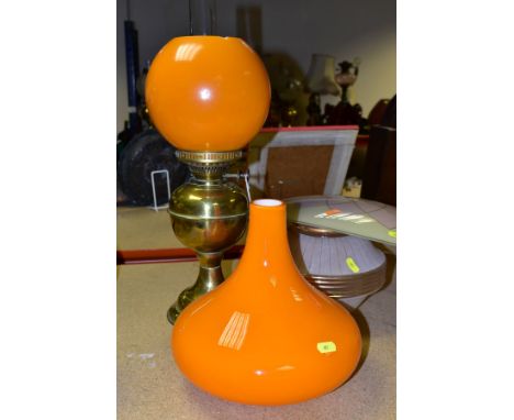 A BRASS OIL LAMP, in working condition with chimney and damaged orange shade, together with a squat orange lamp shade, circa 